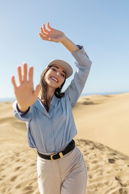 Mujer sonriente de tiro medio en el desierto con sombrero de camionero