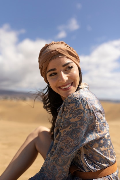 Mujer sonriente de tiro medio en el desierto