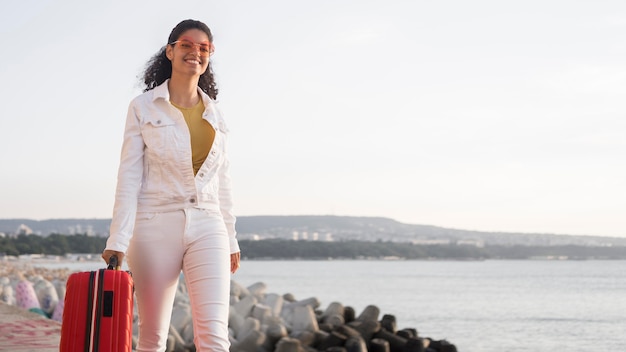 Mujer sonriente de tiro medio con equipaje