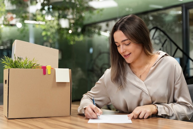 Foto gratuita mujer sonriente de tiro medio escribiendo renuncia