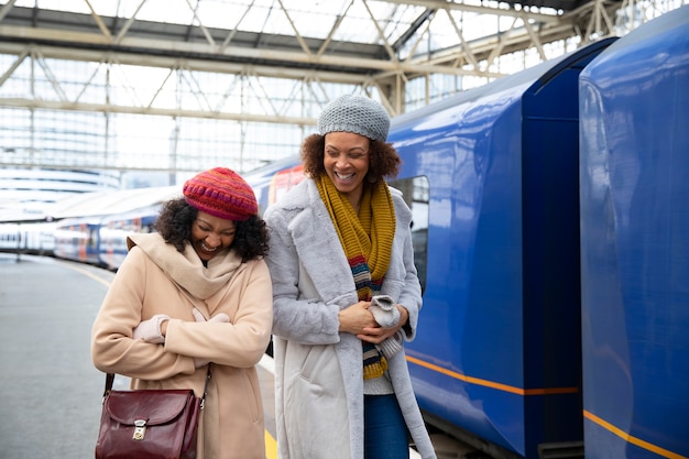 Mujer sonriente de tiro medio en la estación de tren