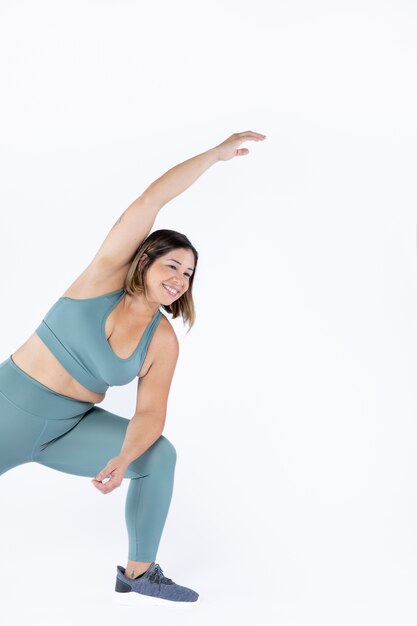 Mujer sonriente de tiro medio estirando