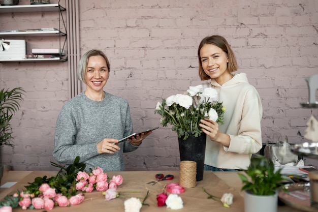 Mujer sonriente de tiro medio en floristería