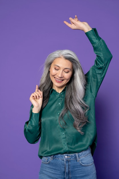 Foto gratuita mujer sonriente de tiro medio con fondo morado