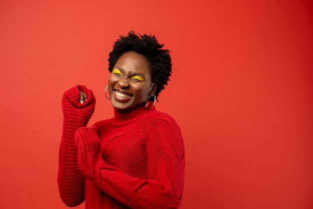 Mujer sonriente de tiro medio con fondo rojo