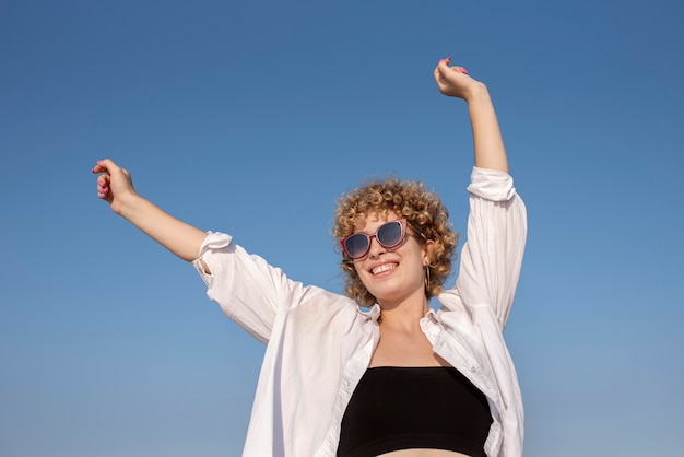 Mujer sonriente de tiro medio con gafas de sol