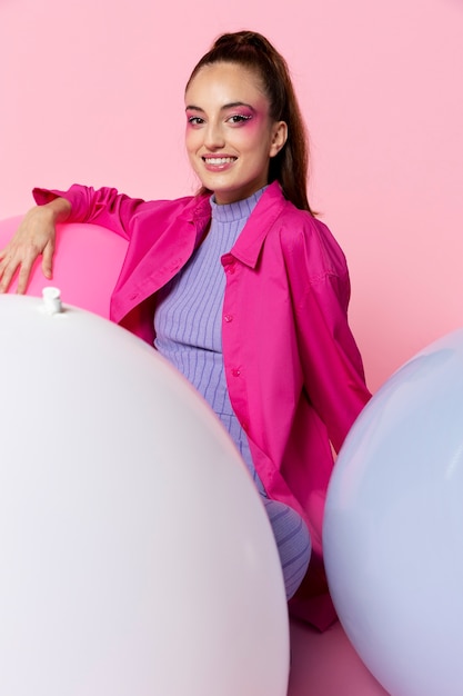 Mujer sonriente de tiro medio con globos