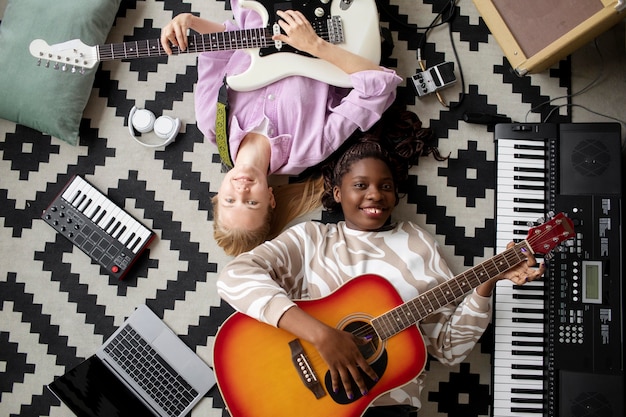 Mujer sonriente de tiro medio con guitarras en el piso