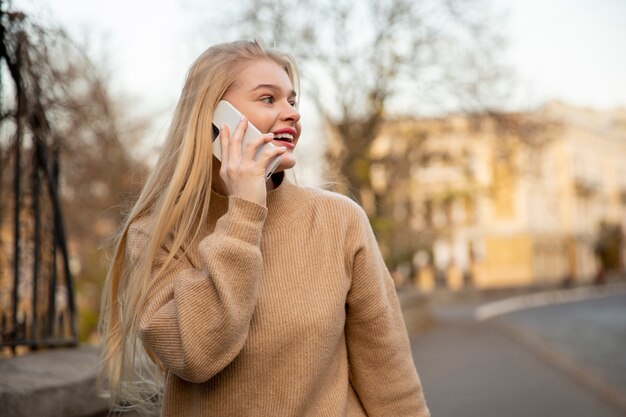 Mujer sonriente de tiro medio hablando por teléfono