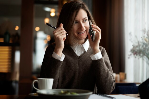 Mujer sonriente de tiro medio hablando por teléfono