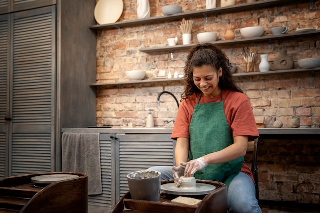 Mujer sonriente de tiro medio haciendo cerámica