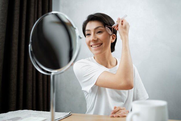 Mujer sonriente de tiro medio haciendo cuidado de la piel