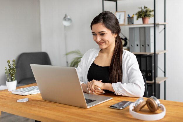 Mujer sonriente de tiro medio haciendo trabajo