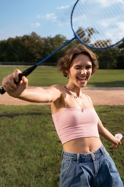 Foto gratuita mujer sonriente de tiro medio jugando bádminton