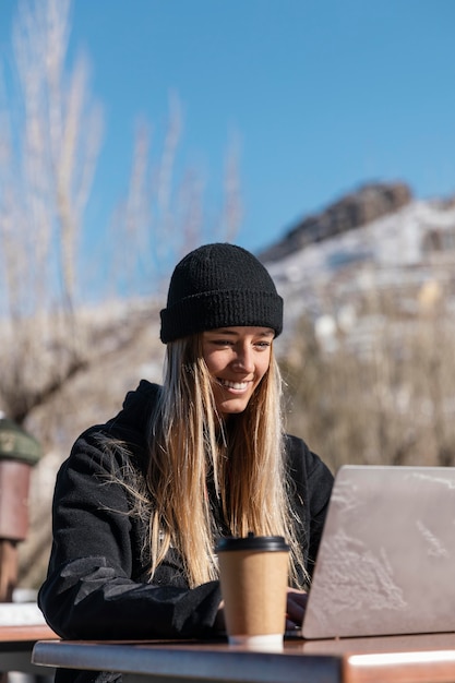 Mujer sonriente de tiro medio con laptop