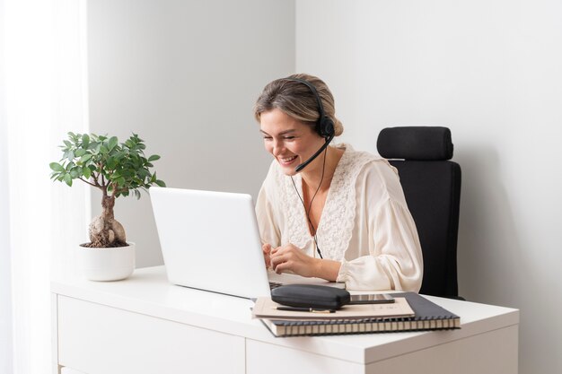 Mujer sonriente de tiro medio con laptop