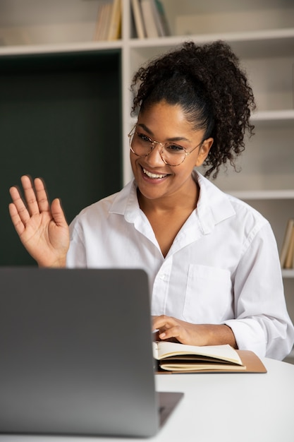 Mujer sonriente de tiro medio con laptop