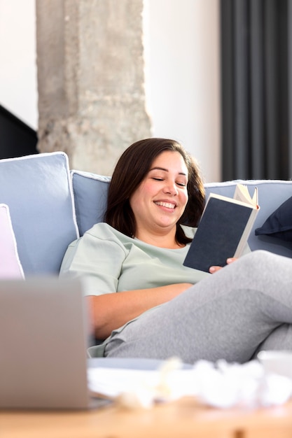 Mujer sonriente de tiro medio leyendo