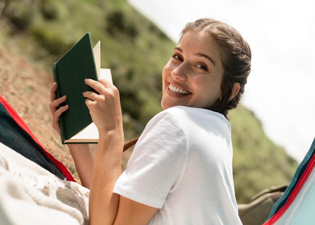 Mujer sonriente de tiro medio con libro