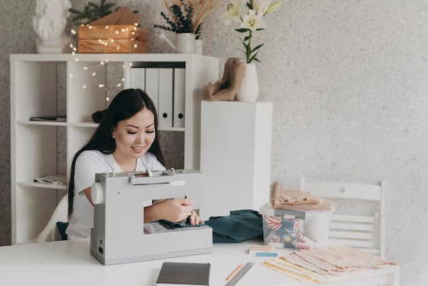 Mujer sonriente de tiro medio con máquina de coser