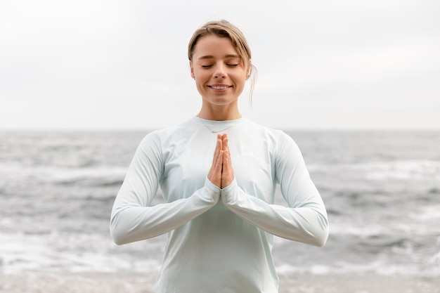 Mujer sonriente de tiro medio meditando