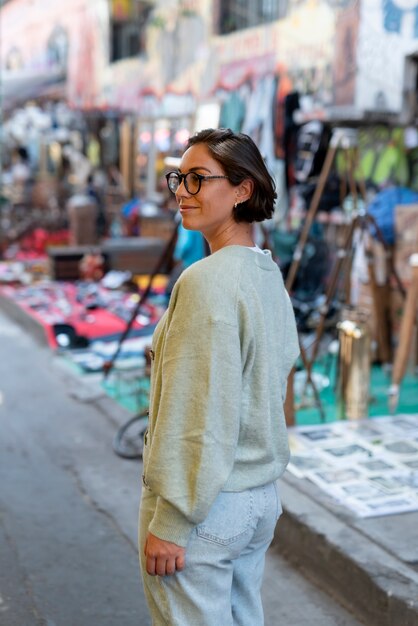 Mujer sonriente de tiro medio en el mercado de segunda mano