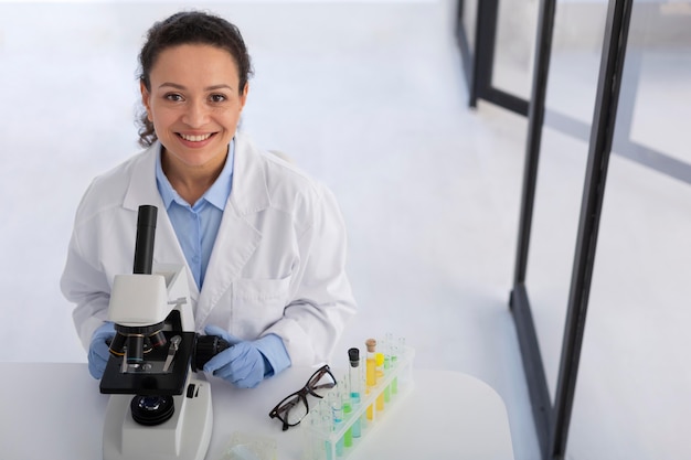 Mujer sonriente de tiro medio con microscopio