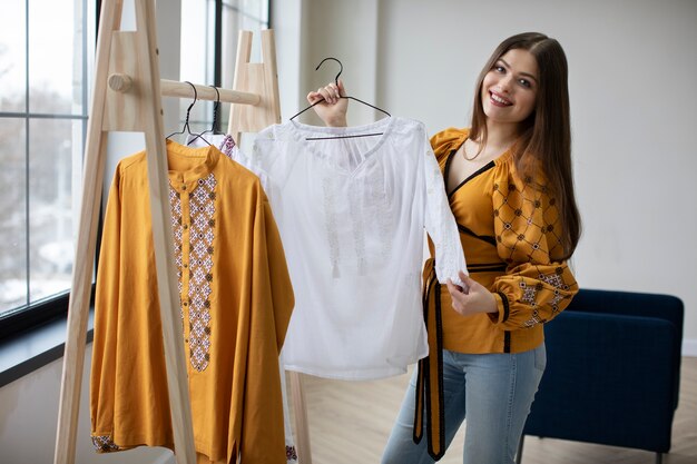 Mujer sonriente de tiro medio mirando la camisa ucraniana