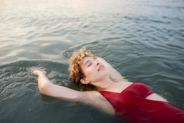 Mujer sonriente de tiro medio nadando