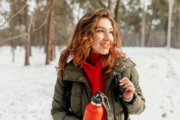 Mujer sonriente de tiro medio en la nieve