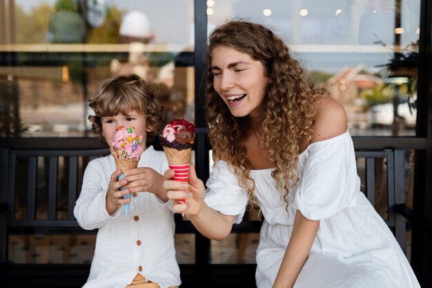 Mujer sonriente de tiro medio y niño con helados
