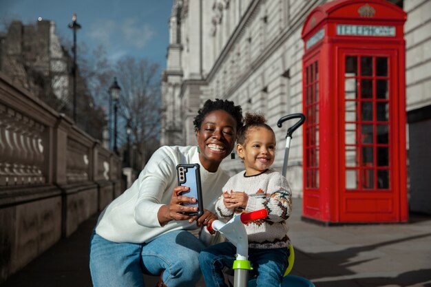 Mujer sonriente de tiro medio y niño tomando selfie