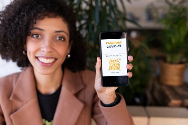 Mujer sonriente de tiro medio con pasaporte de vacunación