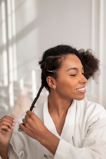 Mujer sonriente de tiro medio peinar el cabello