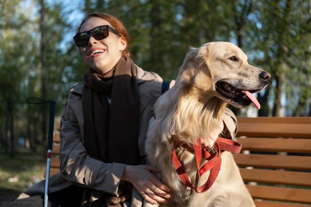 Mujer sonriente de tiro medio con perro de servicio