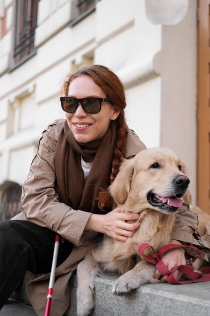 Foto gratuita mujer sonriente de tiro medio con perro de servicio