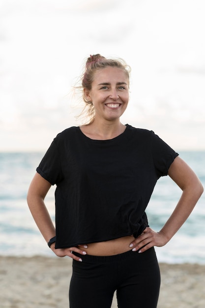 Mujer sonriente de tiro medio en la playa