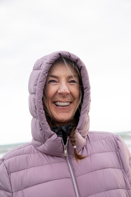 Mujer sonriente de tiro medio en la playa