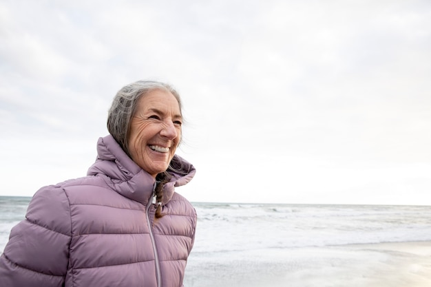 Mujer sonriente de tiro medio en la playa