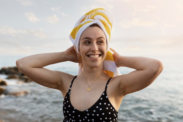 Foto gratuita mujer sonriente de tiro medio en la playa