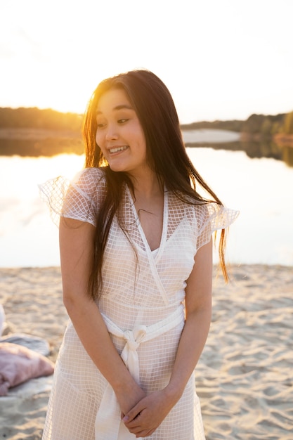 Mujer sonriente de tiro medio en la playa