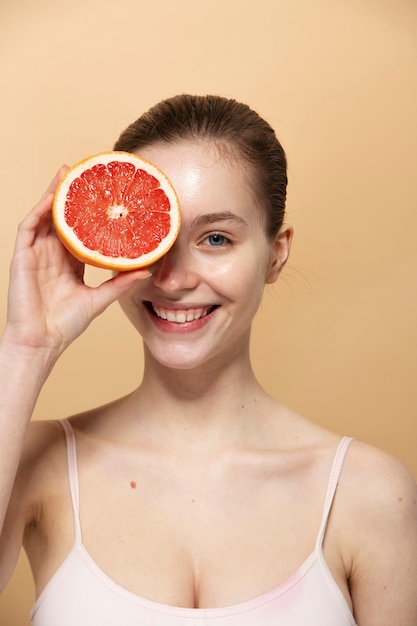 Mujer sonriente con tiro medio de pomelo