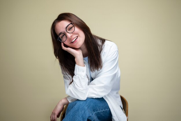 Mujer sonriente de tiro medio posando en una silla