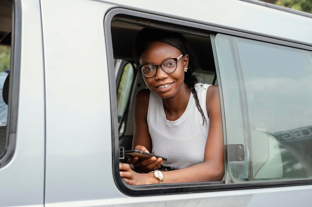 Mujer sonriente de tiro medio sentada en el coche