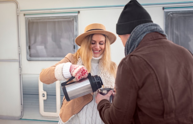 Mujer sonriente de tiro medio sirviendo café