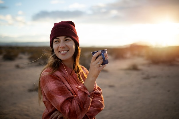 Mujer sonriente de tiro medio sosteniendo taza