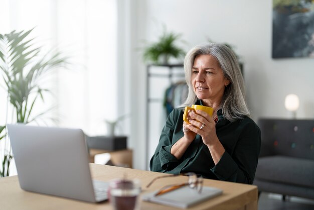 Mujer sonriente de tiro medio sosteniendo taza