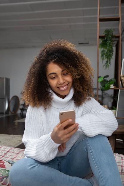 Foto gratuita mujer sonriente de tiro medio sosteniendo teléfono