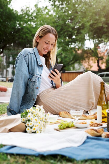 Mujer sonriente de tiro medio sosteniendo teléfono