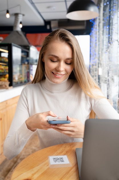 Mujer sonriente de tiro medio sosteniendo teléfono